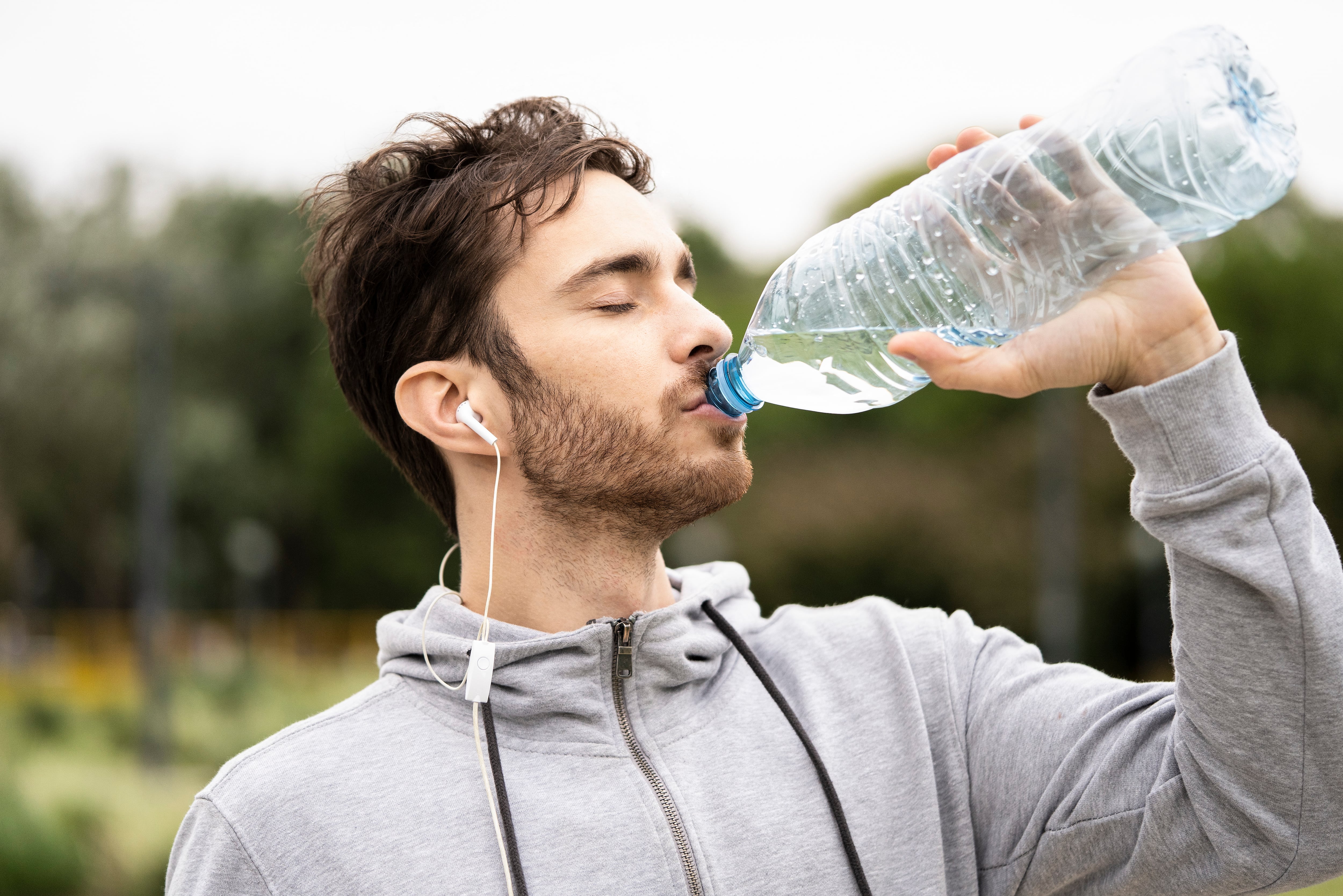 Hombre bebiendo agua de una botella (Foto vía Getty Images)
