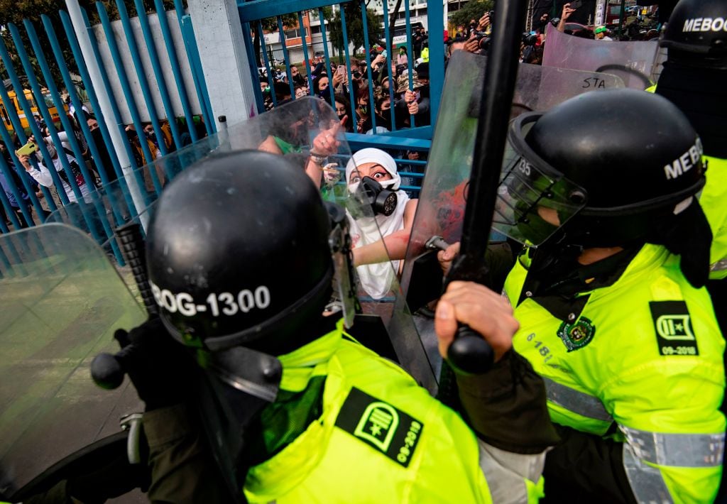 TOPSHOT - An activist argues with riot police during a protest called by feminist groups to denounce an alleged rape of a girl by a doctor in a private clinic and against police brutality in  Bogota on September 10, 2020. (Photo by Juan BARRETO / AFP) (Photo by JUAN BARRETO/AFP via Getty Images)