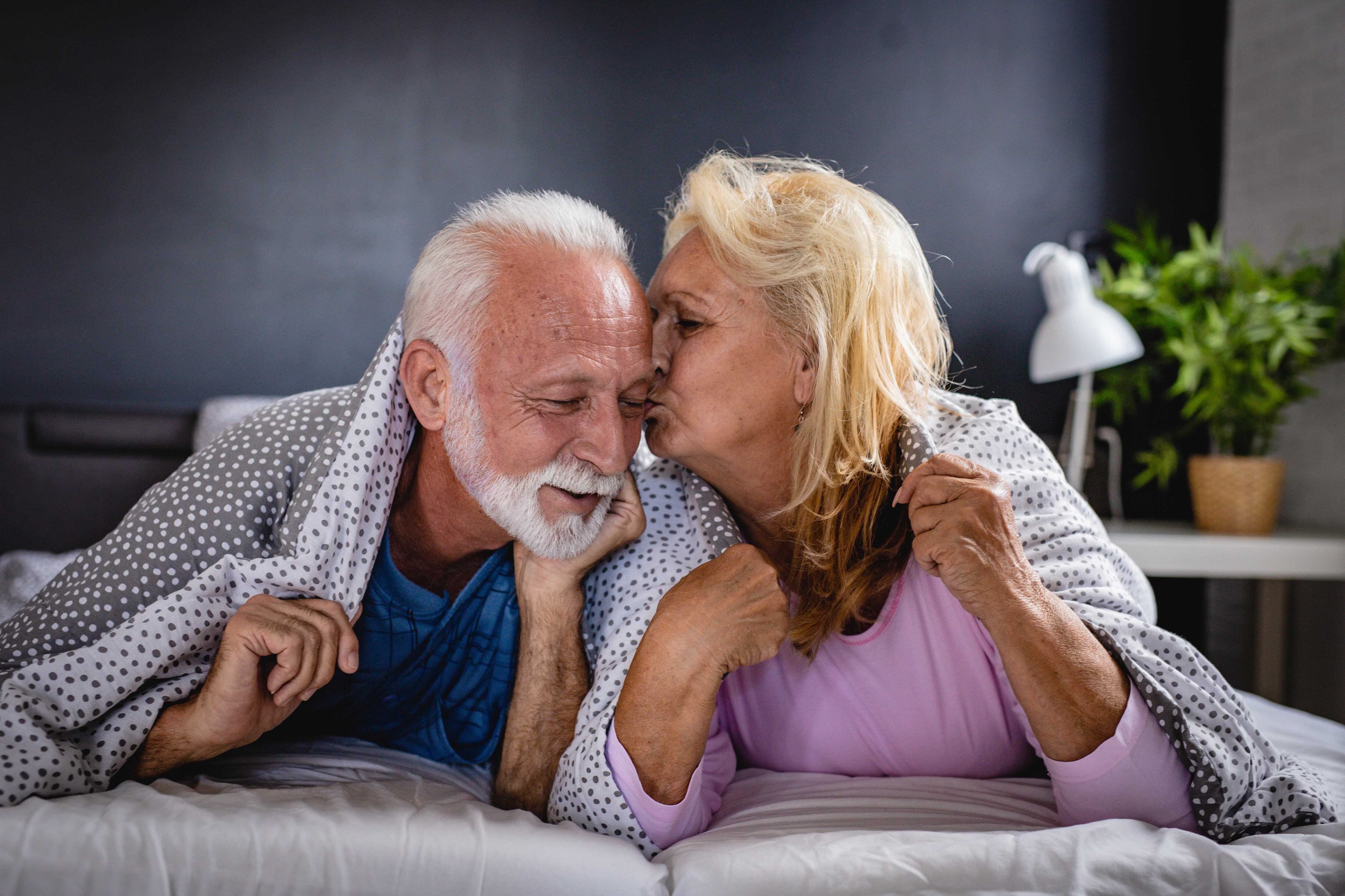 Adultos mayores dándose un beso/ Gettyimagenes