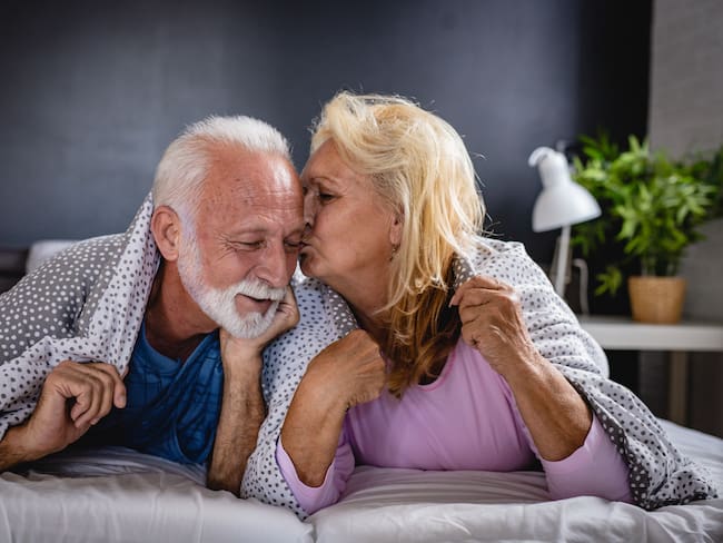 Adultos mayores dándose un beso/ Gettyimagenes