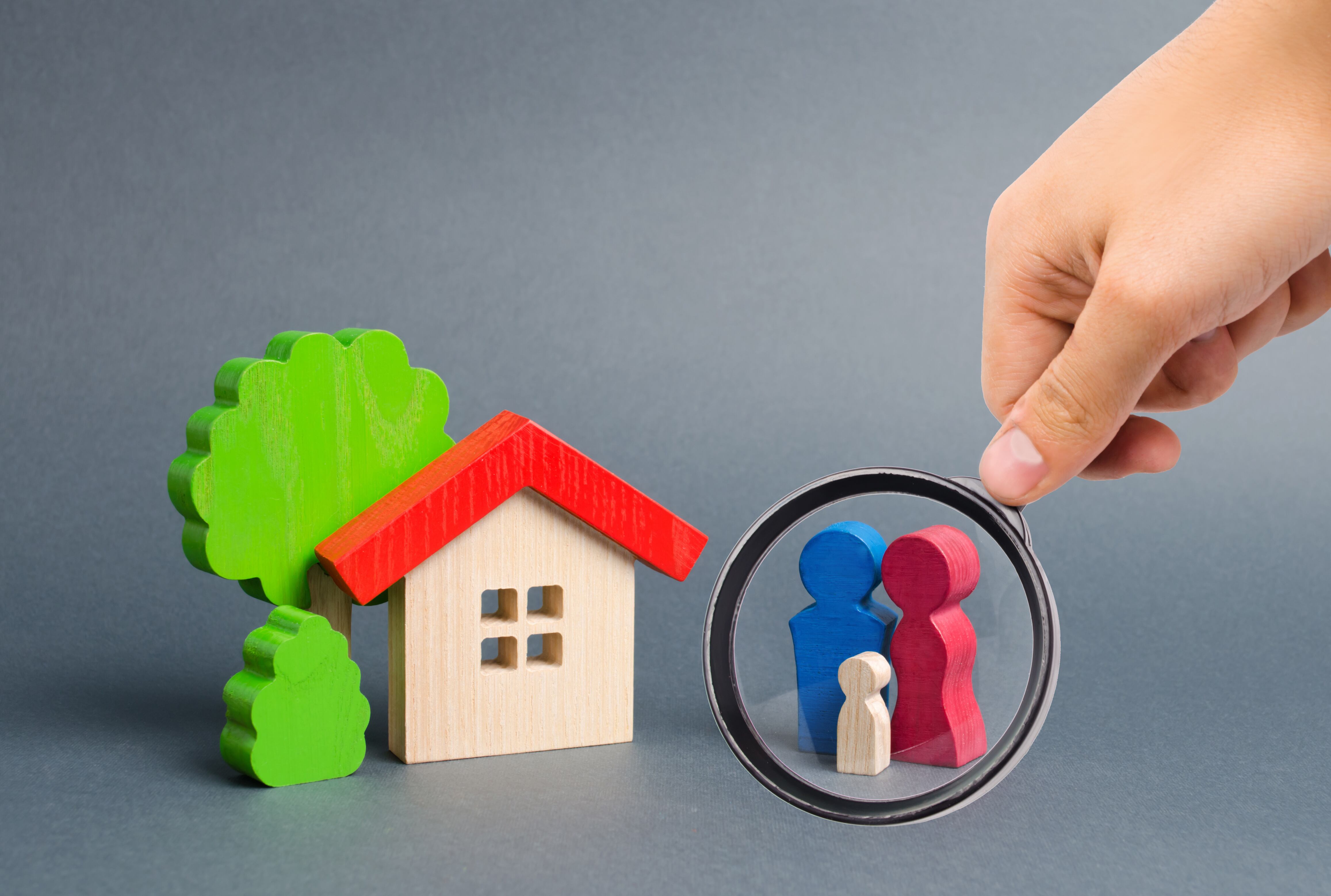Lupa enfocando la figura de una familia que esta junto a una casa (Getty Images)