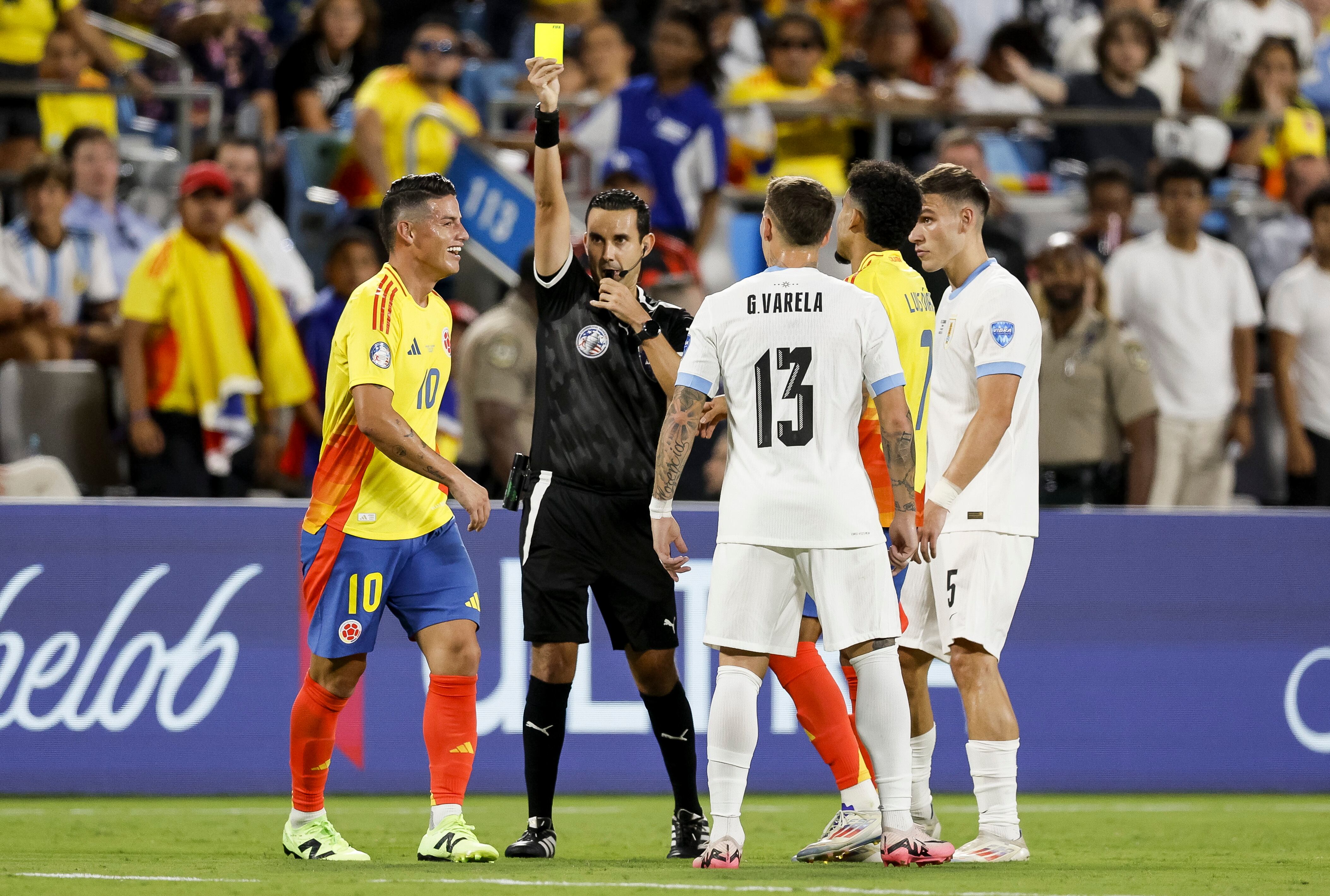 Charlotte (United States), 11/07/2024.- Colombia's James Rodriguez (L) is given a yellow card by referee Cesar Ramos (2-R) during the second half of the CONMEBOL Copa America 2024 semi-finals match between Uruguay and Colombia at Bank of America stadium in Charlotte, North Carolina, USA, 10 July 2024. EFE/EPA/ERIK S. LESSER