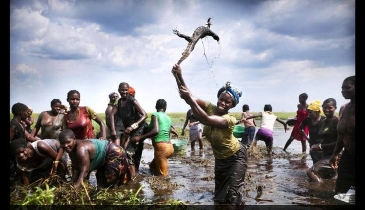 El retrato de una mujer con un lagarto de agua en Zambia fue captado por la cámara de Félix Clay para la productora Duckrabbit. Aquí se ve a un grupo de mujeres limpiando los llanos inundados de algas para luego intentar la pesca a mano.