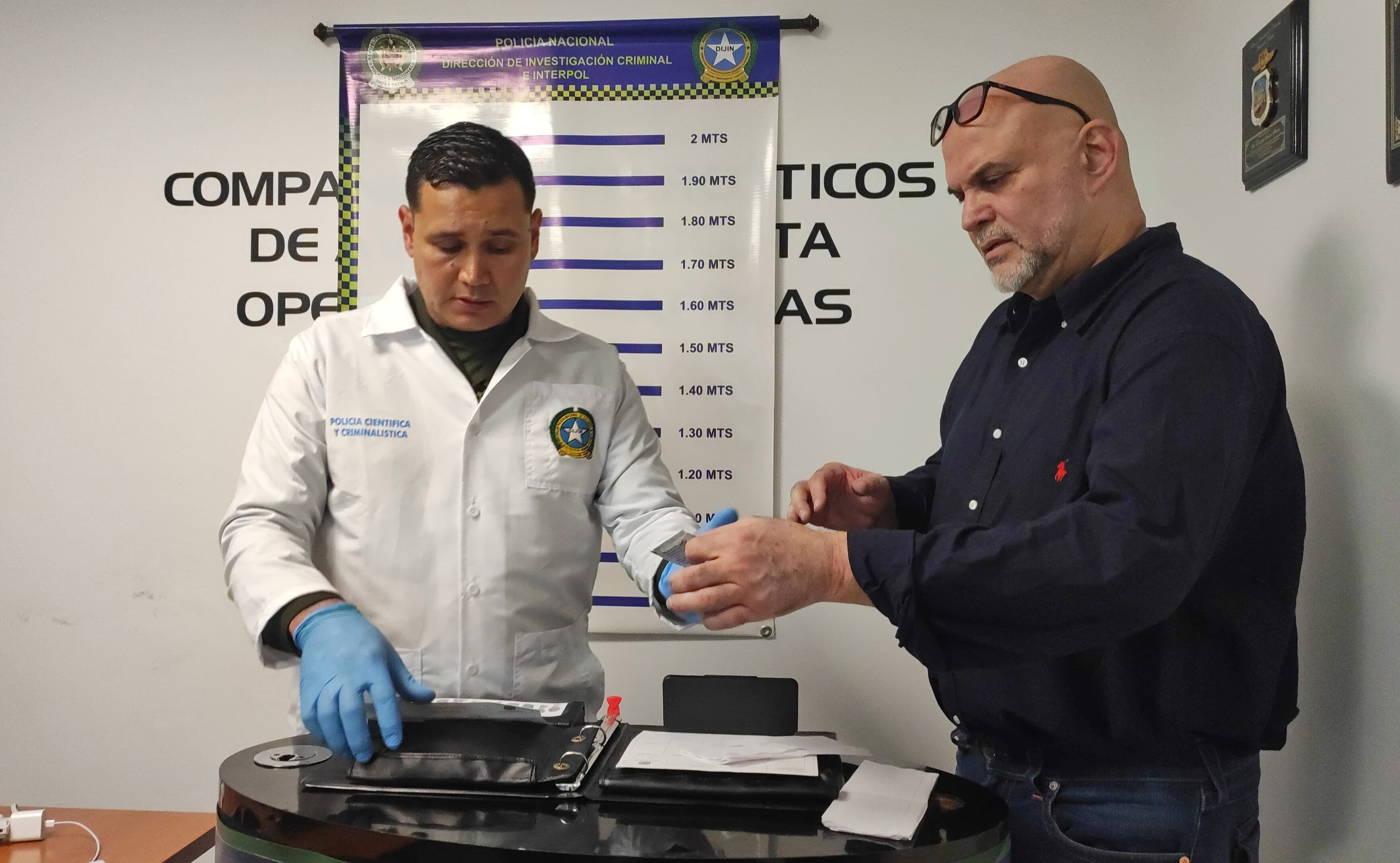 AME2878. BOGOTÁ (COLOMBIA), 27/02/2024.- Fotografía cedida por la Policía de Colombia que muestra al exjefe paramilitar Salvatore Mancuso (d), quien fue comandante de las Autodefensas Unidas de Colombia (AUC), mientras es registrado por las autoridades tras ser deportado por los Estados Unidos este martes en Bogotá (Colombia). Mancuso venía en un vuelo chárter de deportados que aterrizó en el Comando Aéreo de Transporte Militar (Catam) de la capital colombiana y ahora tendrá que comparecer ante la Justicia de Colombia por decenas de crímenes cometidos durante el conflicto armado. EFE/ Policía de Colombia/SOLO USO EDITORIAL/SOLO DISPONIBLE PARA ILUSTRAR LA NOTICIA QUE ACOMPAÑA (CRÉDITO OBLIGATORIO)
