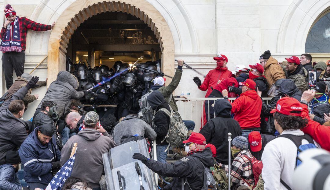 Manifestantes pro Trump forcejeando con la policía antes de entrar al Capitolio de Washington.