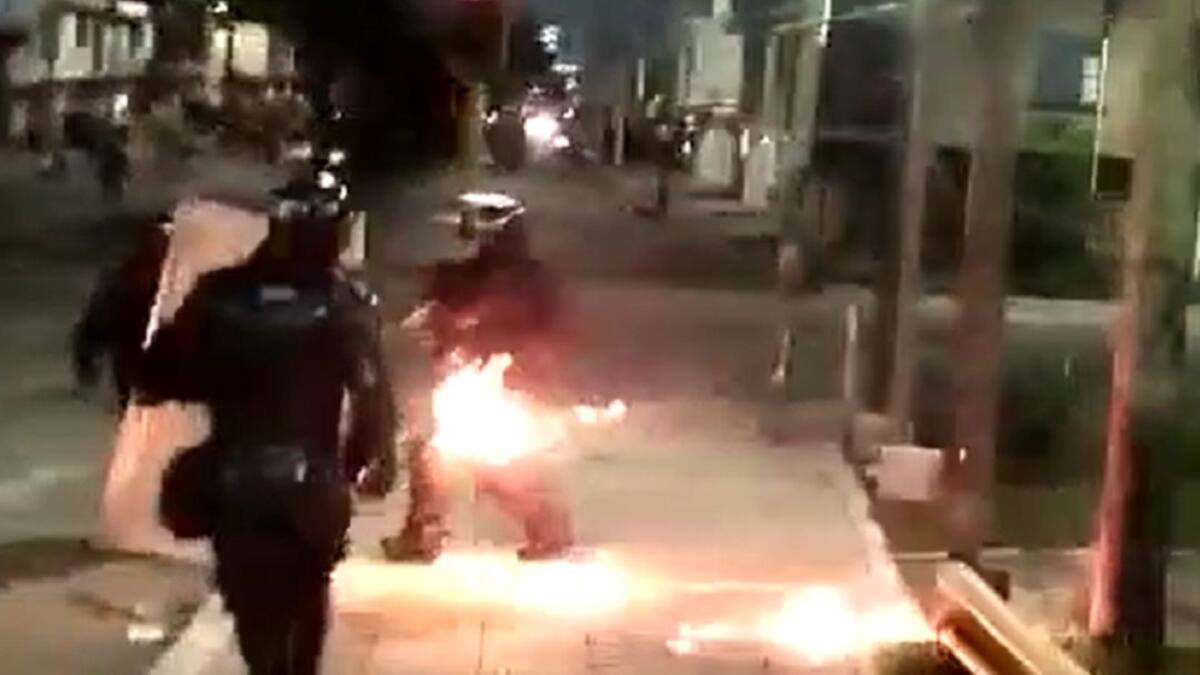 Manifestantes lanzan bomba incendiaria contra agente del ESMAD en Buga