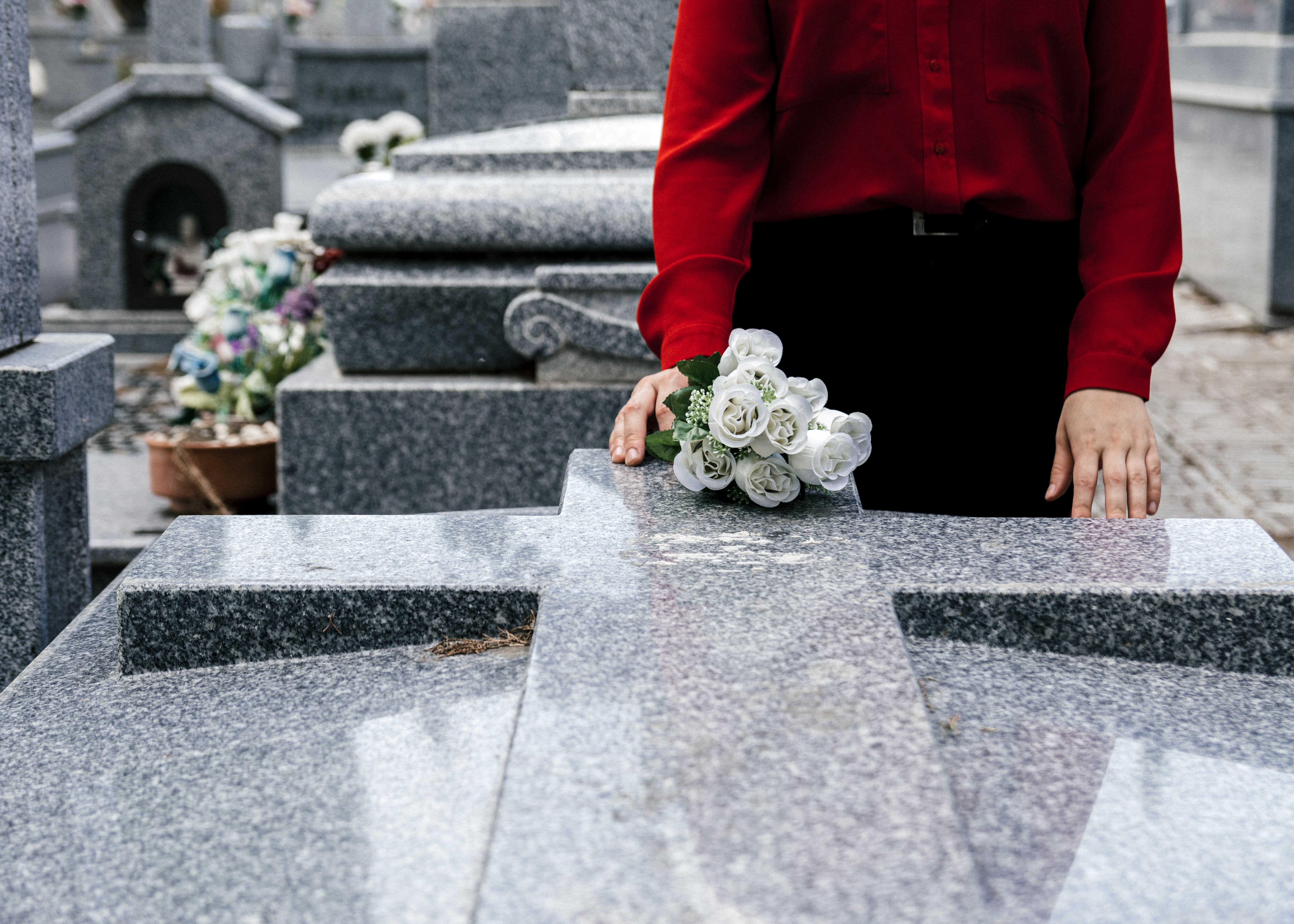 Mujer visitando la tumba de un fallecido (Foto vía Getty Images)