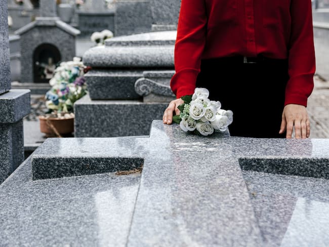 Mujer visitando la tumba de un fallecido (Foto vía Getty Images)