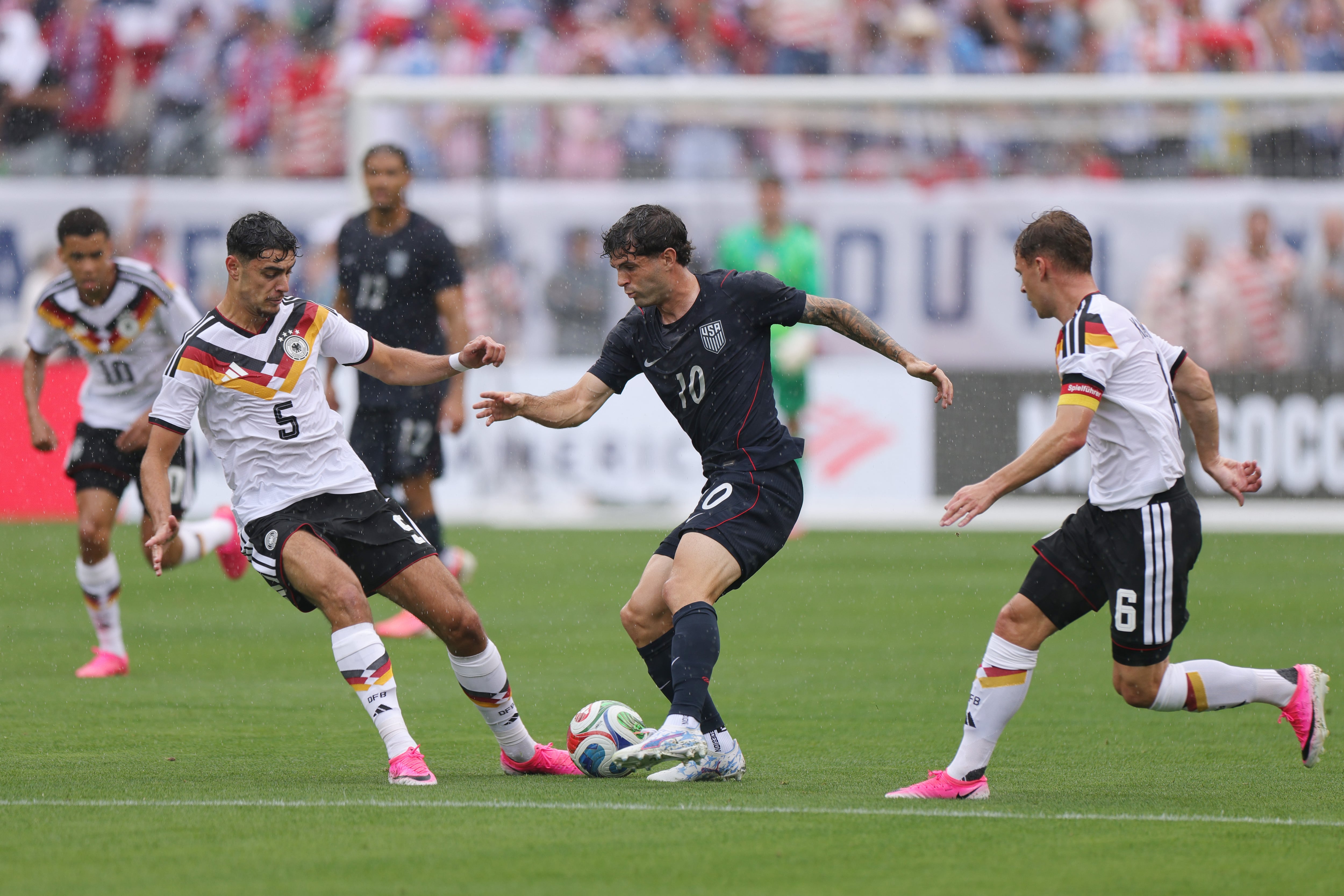 Christian Pulisic of United States is challenged by Aleksander Pavlovic and Joshua Kimmich  (Photo by John Dorton/USSF/Getty Images)