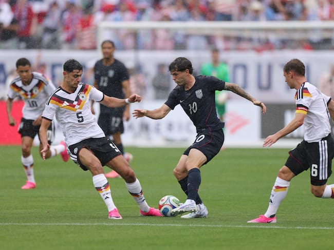 Christian Pulisic of United States is challenged by Aleksander Pavlovic and Joshua Kimmich (Photo by John Dorton/USSF/Getty Images)