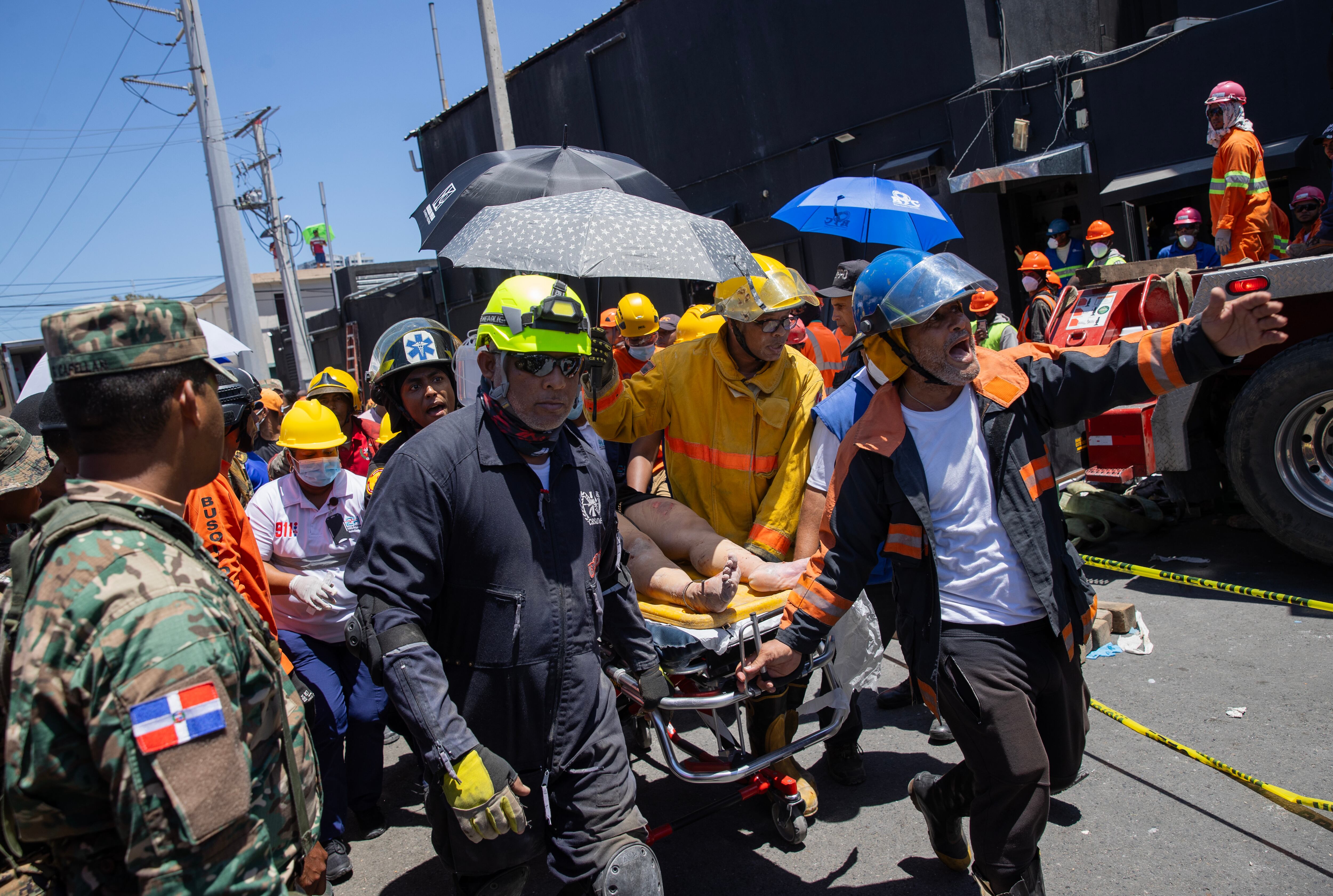 AME7059. SANTO DOMINGO (REPÚBLICA DOMINICANA), 08/04/2025.- Una mujer es trasladada luego de ser rescatada en la discoteca Jet Set este martes, en Santo Domingo (República Dominicana). Los fallecidos por el desplome del techo de la discoteca Jet Set esta madrugada se elevan ya a 44, mientras continúan las labores de rescate de las personas atrapadas entre los escombros, según los últimos datos facilitados por el Centro de Operaciones de Emergencias (COE). EFE/ Orlando Barría