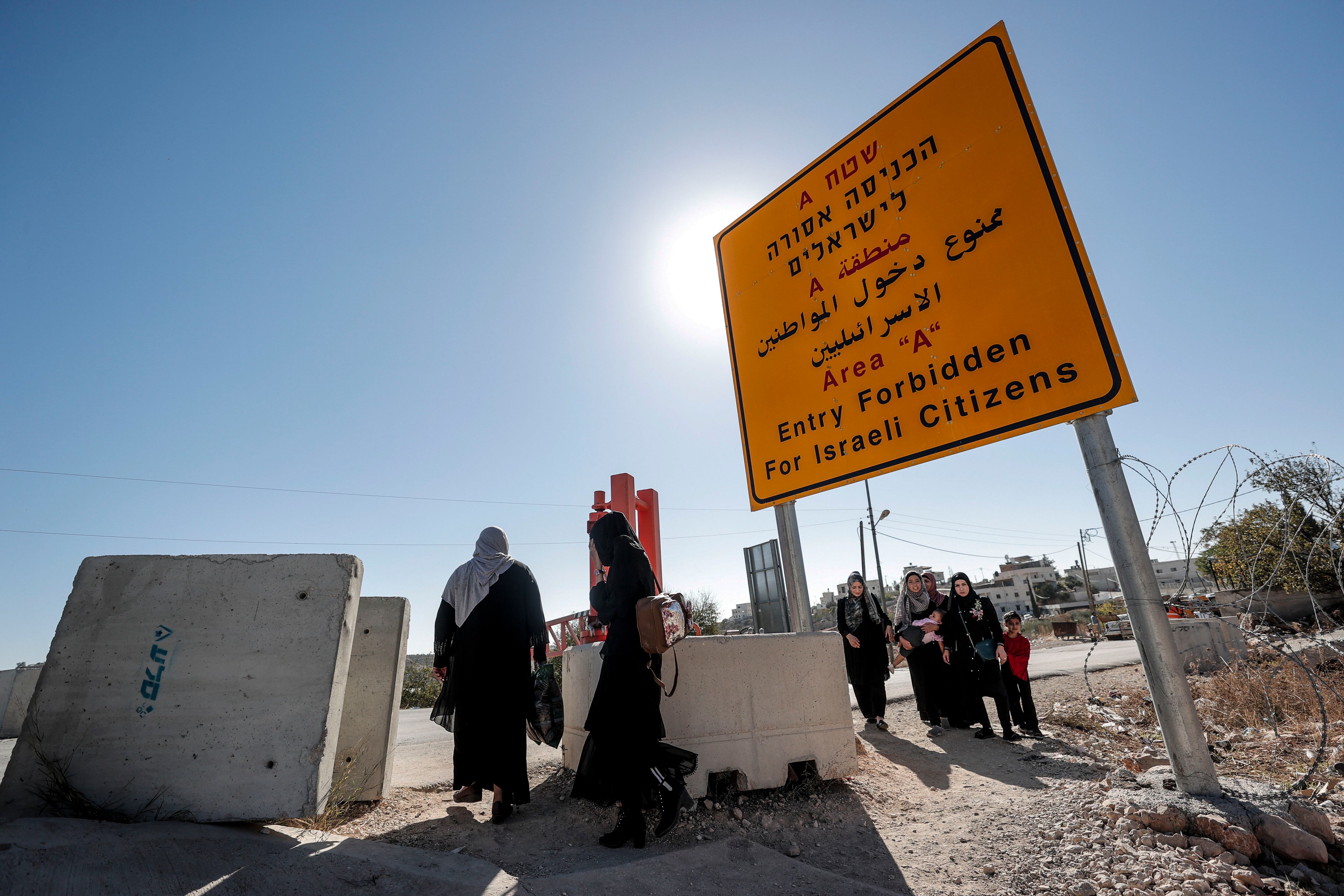 Hebrón, (Cisjordania), 9/11/2023. Un grupo de personas se dirige caminando hacia la carretera para cruzar desde Qilqis hasta Hebrón, en los territorios ocupados de Cisjordania este jueves, debido a que el ejército israelí ha cortado los accesos al tráfico rodado a ambas ciudades, obligando a quien quiera entrar o salir de alguna de ellas a hacerlo a pie.- EFE/ Manuel Bruque