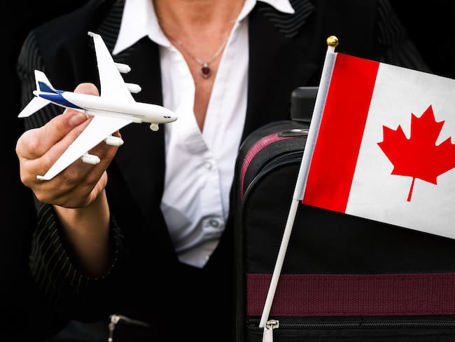 Mujer de negocios, con maleta de viaje, para viajar a Canadá (Getty Images)