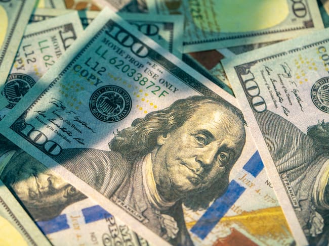 Multiple one hundred dollar bills featuring benjamin franklin are scattered and overlapping, (Credito: Witthaya Prasongsin /Getty imagenes)