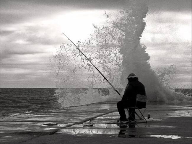Caña, anzuelo, silla, agua y esperanza. Lo único que le falta a este pescador catalán es un pescado para la cena. Foto: Phil Murphy
