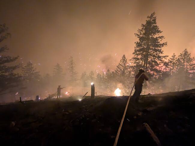 This handout photo taken on August 7, 2026, and released on August 8 by the BC Wildlife Service shows firefighters battling the Bald Range wildfire near Summerland in Canada's western British Columbia province. Canadian officials declared a state of emergency August 8 after a fast-moving wildfire in the western province of British Columbia forced the overnight evacuation of more than 20,000 people, including some who were airlifted to safety. (Photo by Handout / BC Wildfire Service / AFP) / -----EDITORS NOTE --- RESTRICTED TO EDITORIAL USE - MANDATORY CREDIT "AFP PHOTO / BC Wildfire Service" - NO MARKETING - NO ADVERTISING CAMPAIGNS - DISTRIBUTED AS A SERVICE TO CLIENTS