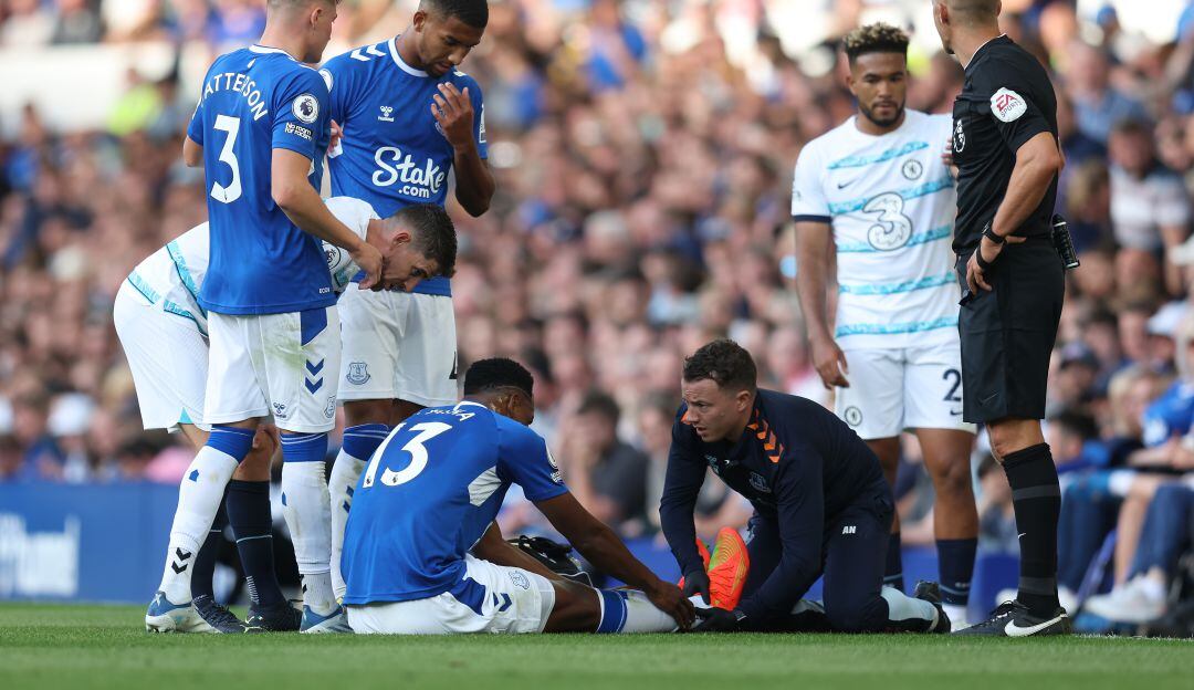 Yerry Mina es atendido por los médicos del Everton tras lesionarse el tobillo derecho.