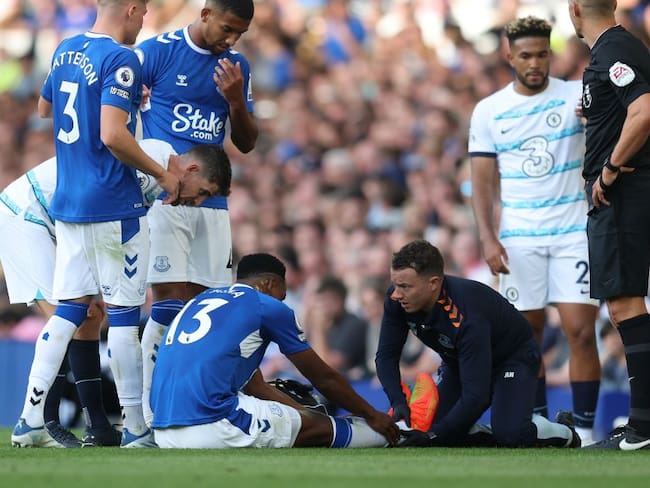 Yerry Mina es atendido por los médicos del Everton tras lesionarse el tobillo derecho.