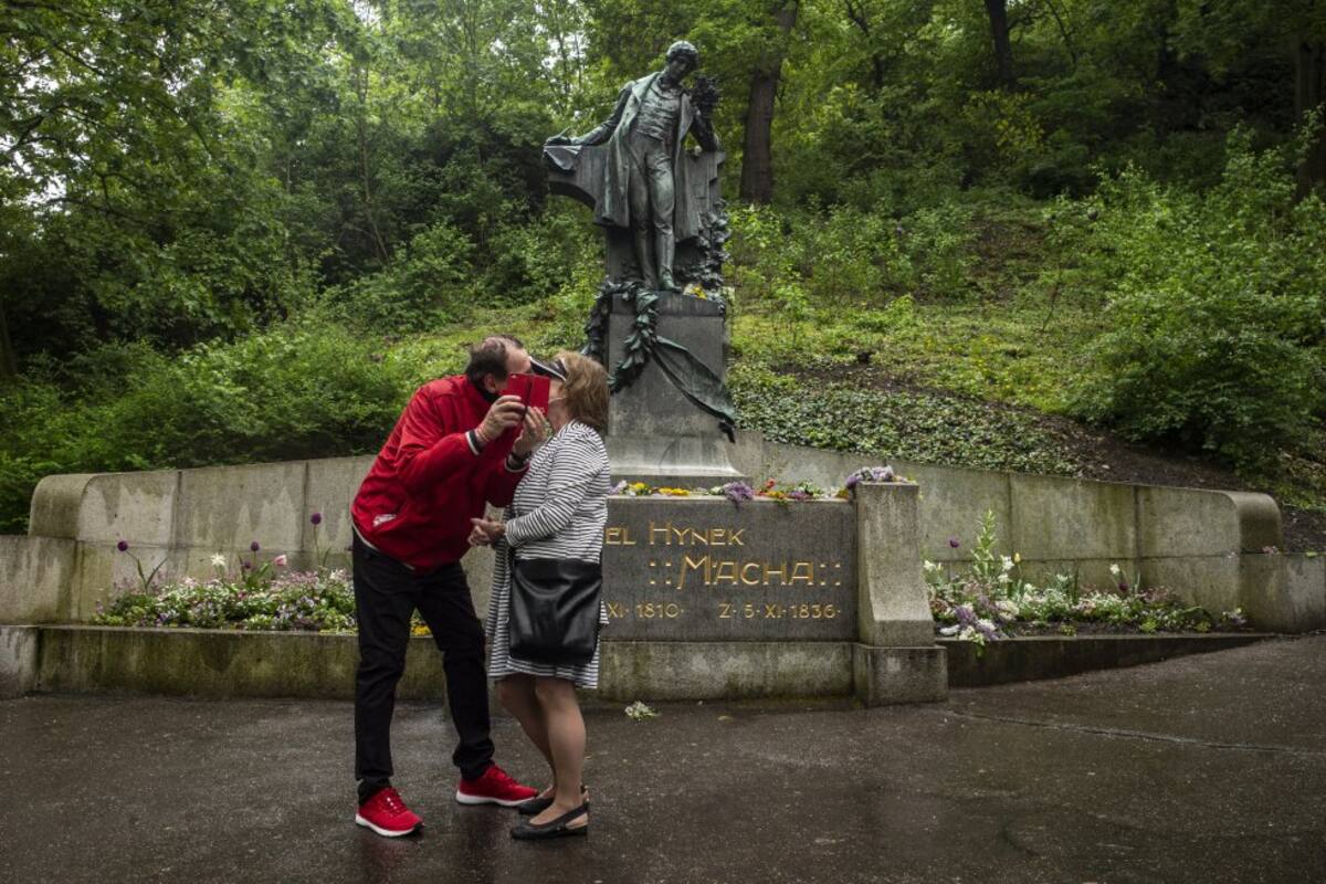 Una pareja se besa bajo la estatua del famoso poeta Karel Hynek Macha como parte de una tradición checa en la colina de Petrin