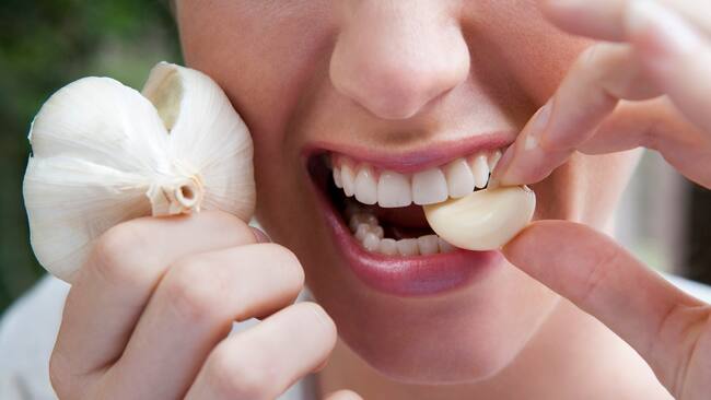Mujer comiendo un diente de ajo (Getty Images)