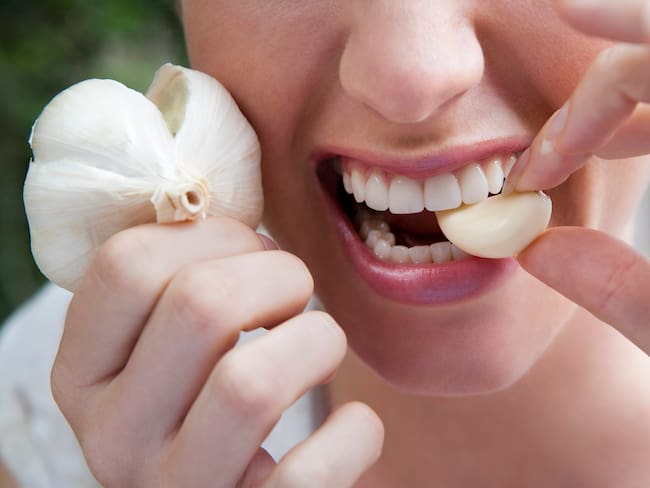 Mujer comiendo un diente de ajo (Getty Images)