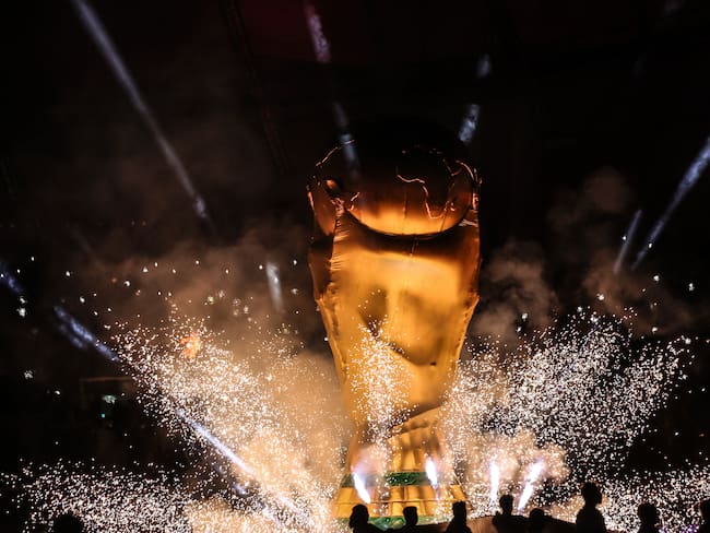DOHA, QATAR - DECEMBER 01:  A giant inflatable replica of the FIFA World Cup trophy is seen surround by fireworks during the FIFA World Cup Qatar 2022 Group E match between Japan and Spain at Khalifa International Stadium on December 1, 2022 in Doha, Qatar. (Photo by Marc Atkins/Getty Images)
