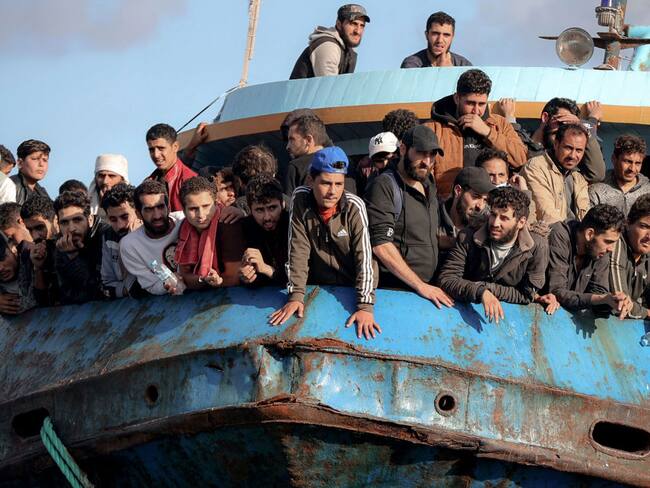 TOPSHOT - Rescued refugees and migrants stand aboard a boat at the town of Paleochora, southwestern Crete island on November 22, 2022, following a rescue operation. (Photo by Costas METAXAKIS / AFP) (Photo by COSTAS METAXAKIS/AFP via Getty Images)