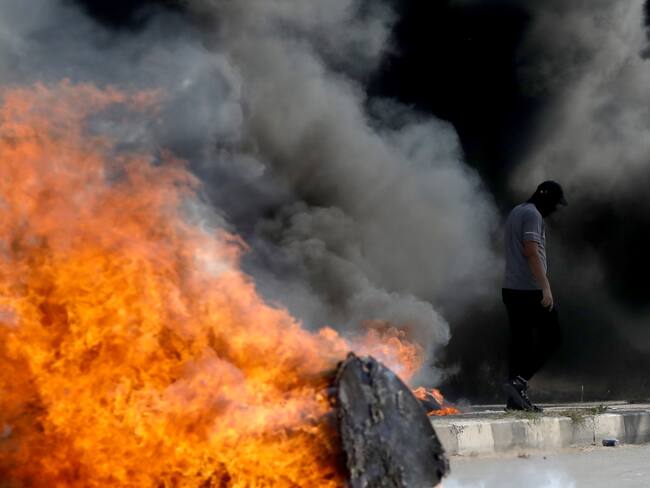 Un palestino busca refugio durante los enfrentamientos con las fuerzas israelíes en la ciudad de Naplusa, en Cisjordania, el 13 de octubre de 2023. EFE/ALAA BADARNEH
