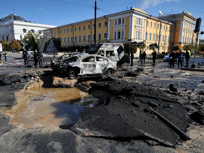 Expertos policiales examinan autos destruidos en el centro de la capital ucraniana de Kyiv después de varios ataques rusos el 10 de octubre de 2022 / AFP