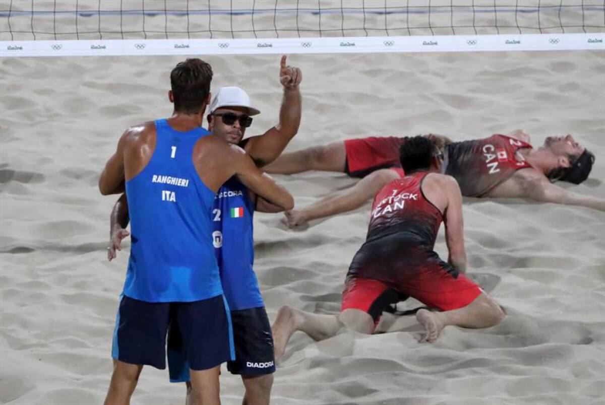 El italiano Alex Ranghieri (i) celebra con su compañero Adrian Carambula (2-i) durante un partido de voleibol de playa entre Italia y Canadá por las Olimpiadas de Río 2016, en la Arena de Copacabana.