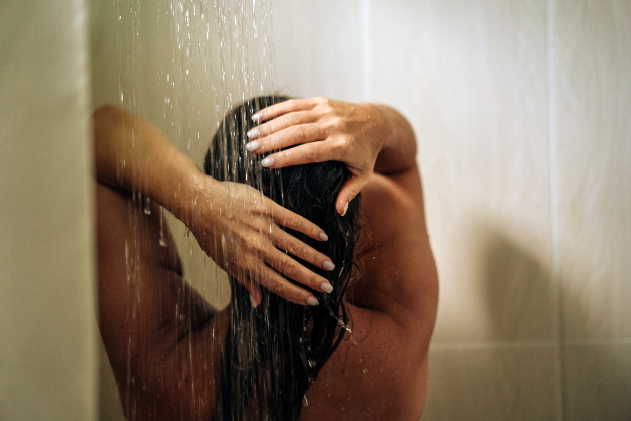 Mujer tomando una ducha prolongada (vía Getty Images)