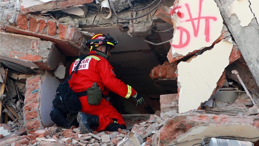 Un bombero intenta escuchar una persona atrapada entre los escombros que dejó el terremoto en Ecuador. Foto: Agencia EFE