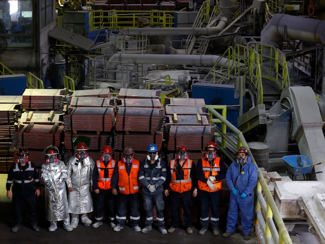 Miners pose in front of copper production at El Teniente mine, the world's largest underground copper mine in Machali, near Rancagua, Chile on April 2, 2025. (Photo by RAUL BRAVO / AFP)