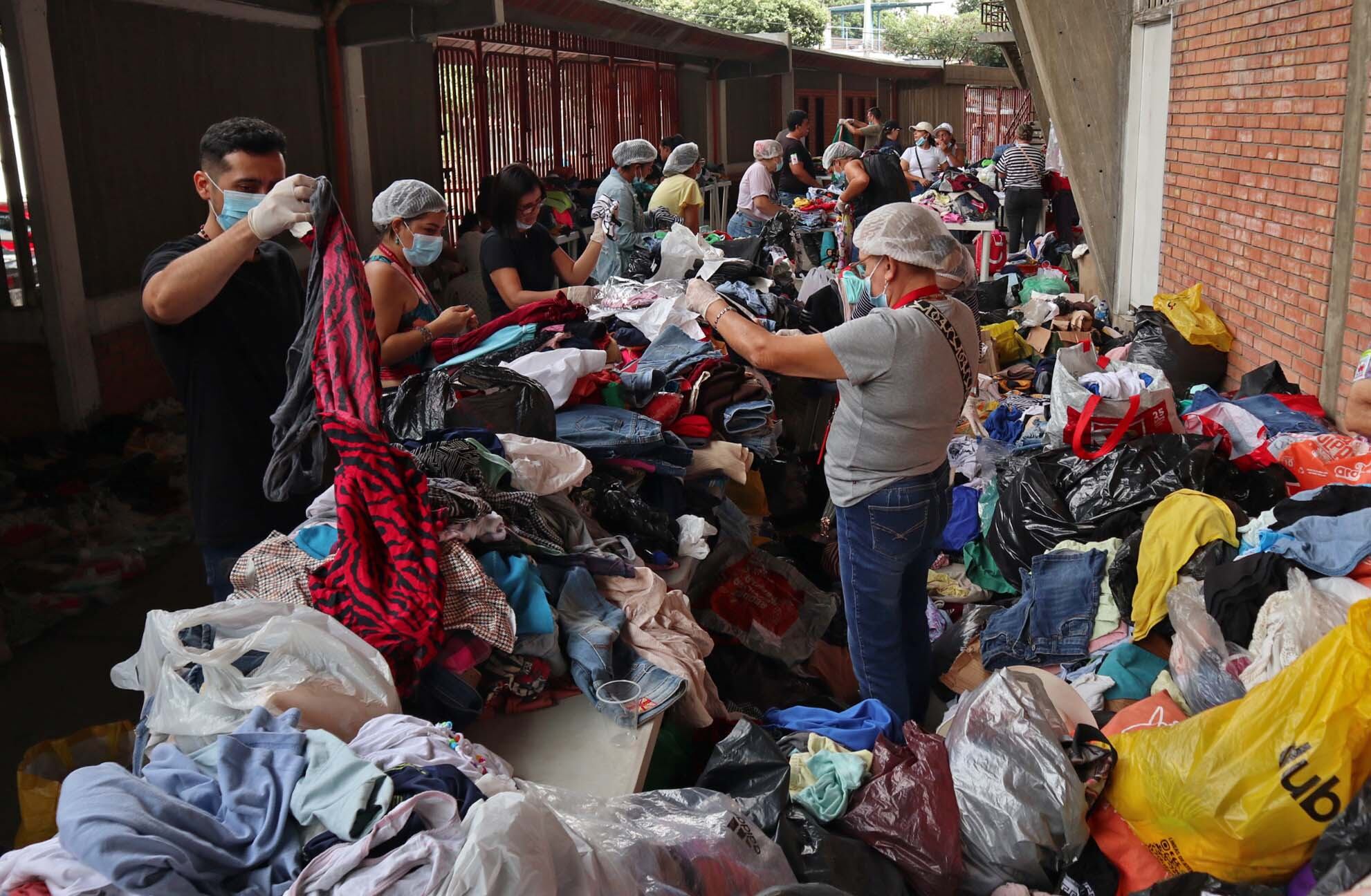Personas clasifican algunas prendas que fueron donadas para los desplazados por la violencia en el Catatumbo este lunes, en el estadio General Santander en Cúcuta (Colombia). EFE/Mario Caicedo