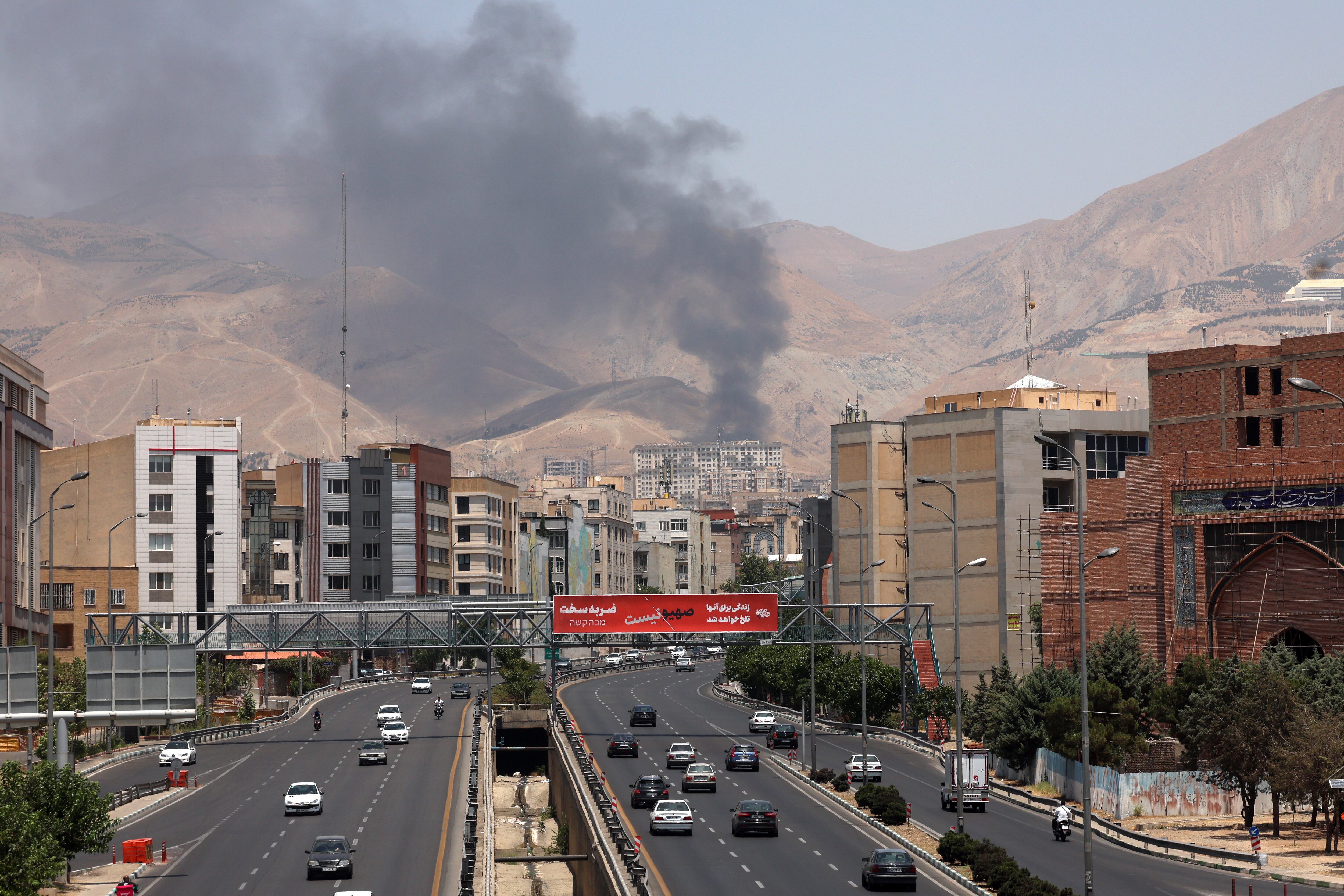 FOTODELDÍA TEHERÁN (IRÁN), 16/06/2025.- Vehículos circulan por una autopista mientras se eleva humo al fondo desde una refinería de petróleo, al noroeste de Teherán, Irán, ESTE LUNES. Israel e Irán han estado intercambiando disparos desde que Israel lanzó ataques en Irán el 13 de junio de 2025 como parte de la Operación "León Ascendente". EFE/ Abedin Taherkenareh