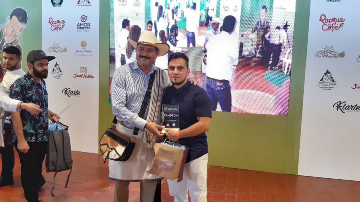 Carlos Eduardo Gómez barista ganador al lado de Juan Valdez
