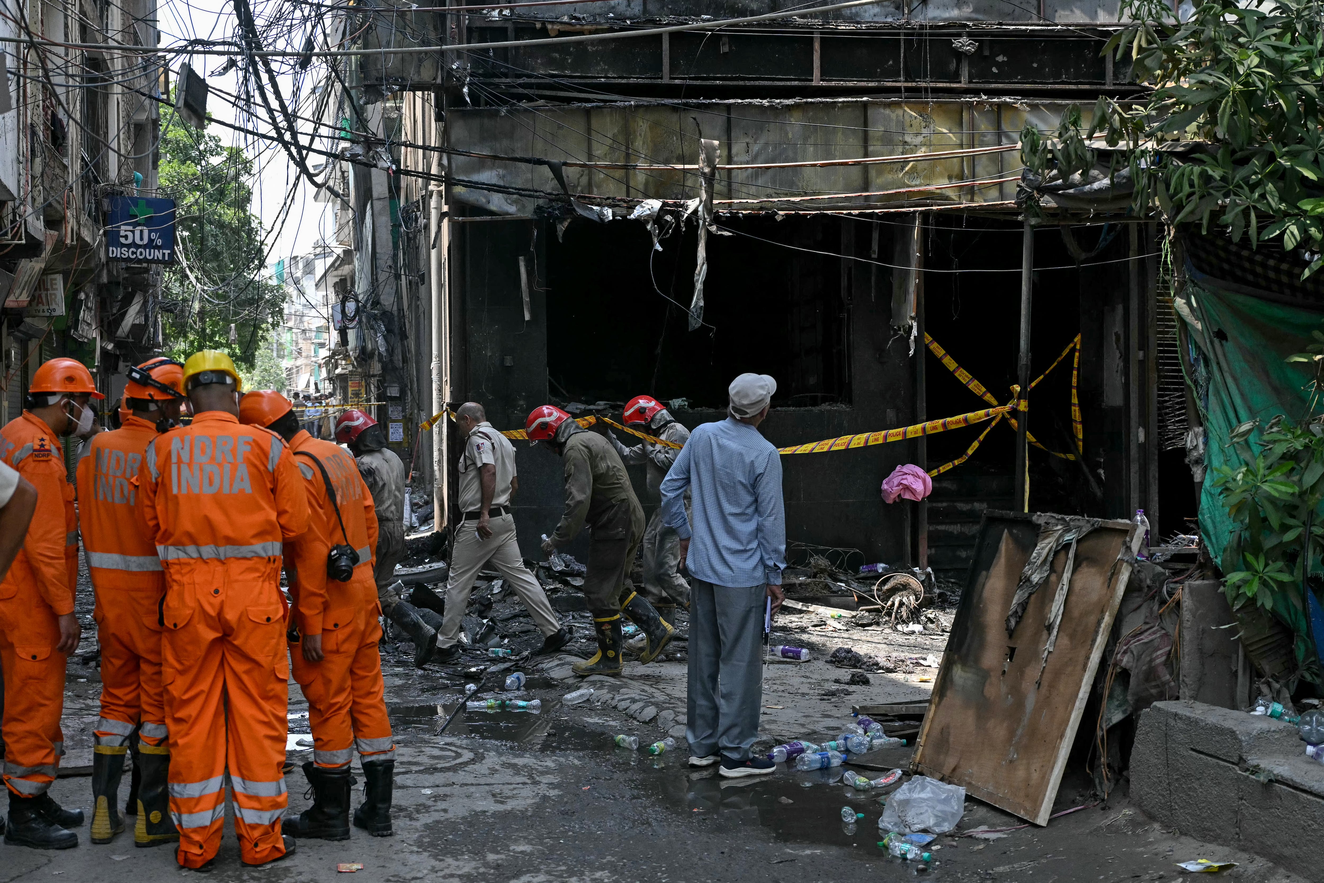 Personal de la Fuerza Nacional de Respuesta ante Desastres (NDRF) y bomberos permanecen en el lugar tras el incendio que se desató en un hotel de Nueva Delhi el 3 de junio de 2026. Al menos 21 personas murieron cuando el incendio arrasó un hotel en Nueva Delhi el 3 de junio, según informó la policía, en uno de los incendios más mortíferos ocurridos en la capital india en los últimos años. (Foto de Arun SANKAR / AFP)