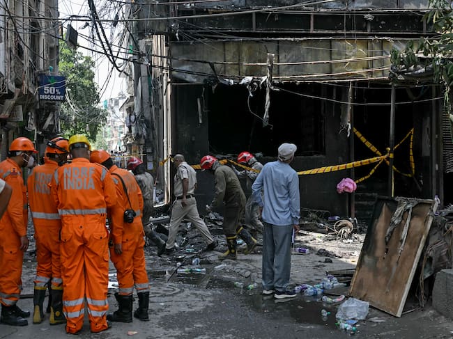 Personal de la Fuerza Nacional de Respuesta ante Desastres (NDRF) y bomberos permanecen en el lugar tras el incendio que se desató en un hotel de Nueva Delhi el 3 de junio de 2026. Al menos 21 personas murieron cuando el incendio arrasó un hotel en Nueva Delhi el 3 de junio, según informó la policía, en uno de los incendios más mortíferos ocurridos en la capital india en los últimos años. (Foto de Arun SANKAR / AFP)