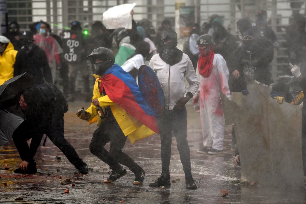 BOGOTA, COLOMBIA - APRIL 28: Demonstrators clash with riot police during a demonstration commemorating last year's national strike on April 28, 2022 in Bogota, Colombia. Social organizations have called for a demonstrations throughout Colombia to commemorate anti-government protests that surged a year ago.  (Photo by Guillermo Legaria Schweizer/Getty Images)