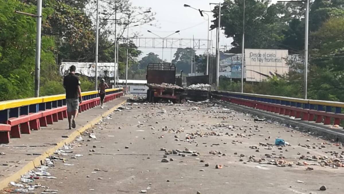 al fondo los tres camiones que  no pudieron pasar con la ayuda humanitaria  