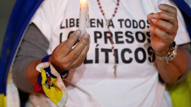 AME6105. CARACAS (VENEZUELA), 17/12/2024.- Una mujer sostiene una vela durante una vigilia por los "presos políticos" en la Universidad Central de Venezuela (UCV) este martes, en Caracas (Venezuela). Familias venezolanas se concentraron para iniciar una vigilia de oración por los tres "presos políticos" fallecidos bajo custodia del estado y, además, para pedir la libertad de aquellos que permanecen en la cárcel por estos motivos, la mayoría detenidos en contexto de protestas poselectorales. EFE/ Ronald Peña