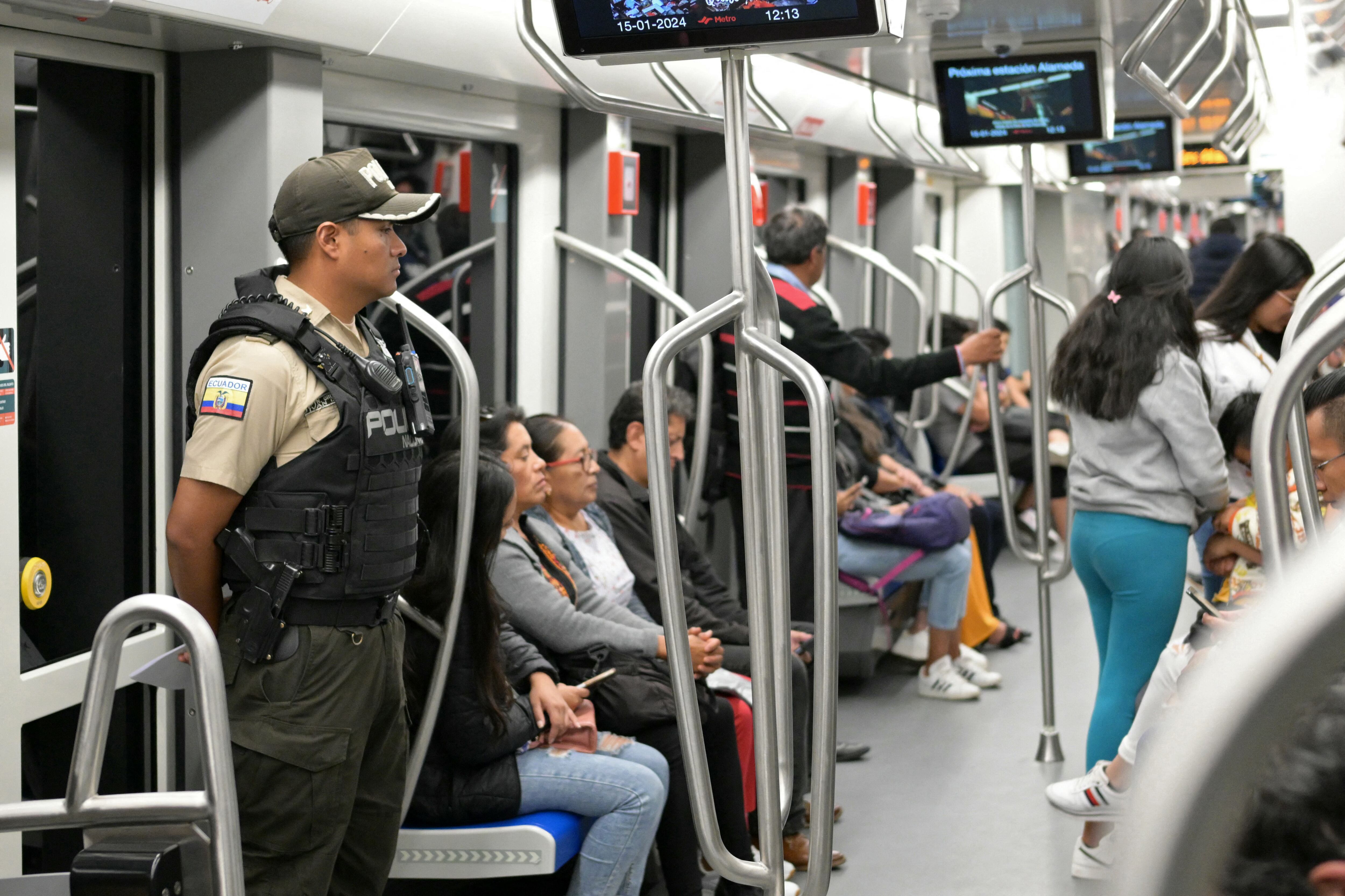 A police officer provides security in a metro in Quito on January 15, 2025, days after the government declared a state of emergency and curfew following the escape from prison of one of the country's most powerful narcotics gang bosses. Ecuador's security forces on Sunday took back control of several prisons that had fallen into the hands of gang members, after securing the release of more than 200 officials held hostage inside the jails. The country's simmering security crisis erupted last week as the government and powerful narco gangs declared all-out war on each other, after the prison escape of a dangerous drug lord, Jose Adolfo Macias, known by the alias "Fito." (Photo by Rodrigo BUENDIA / AFP) (Photo by RODRIGO BUENDIA/AFP via Getty Images)
