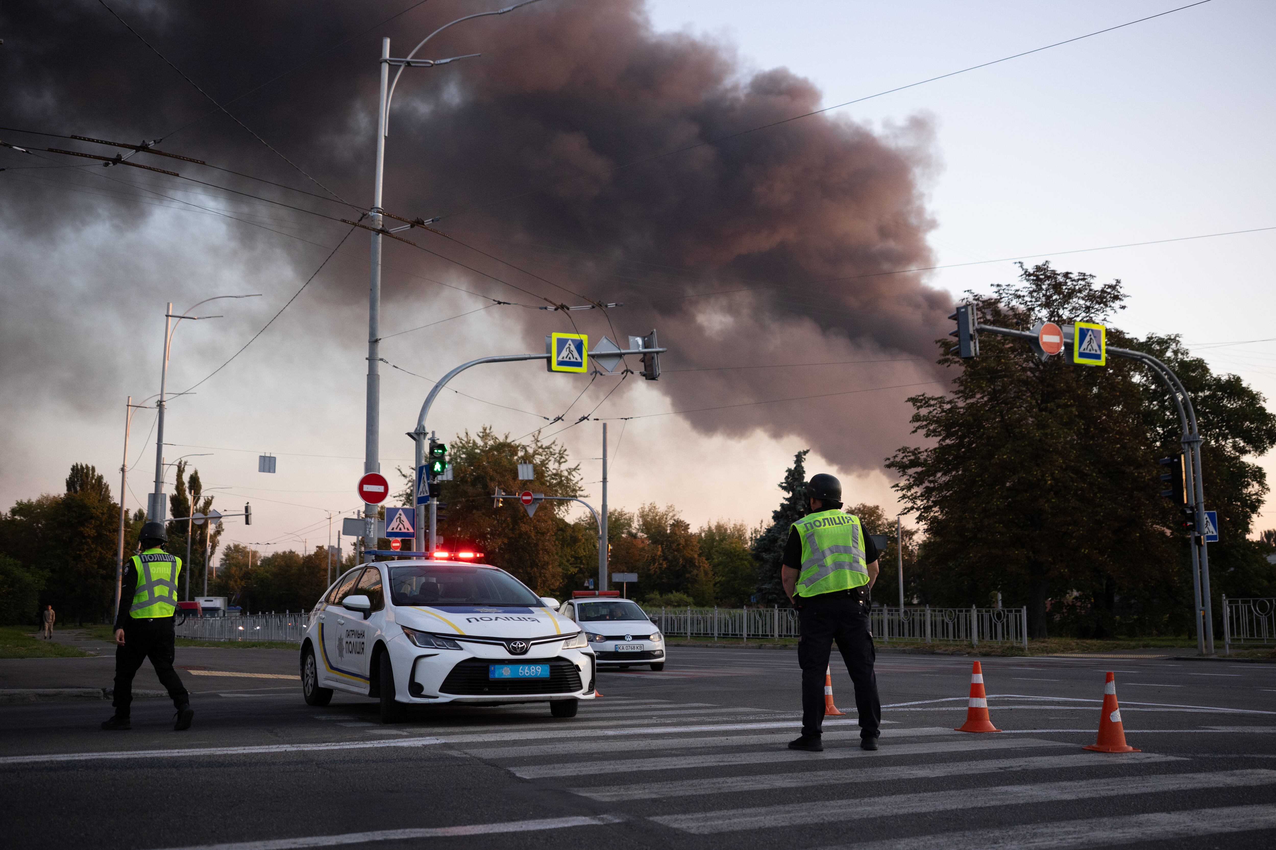 Agentes de policía observan en un cruce de caminos una columna de humo que se eleva hacia el cielo el 7 de septiembre de 2025 en Kiev, Ucrania. (Foto de Oleksandr Magula/Global Images Ucrania vía Getty Images)