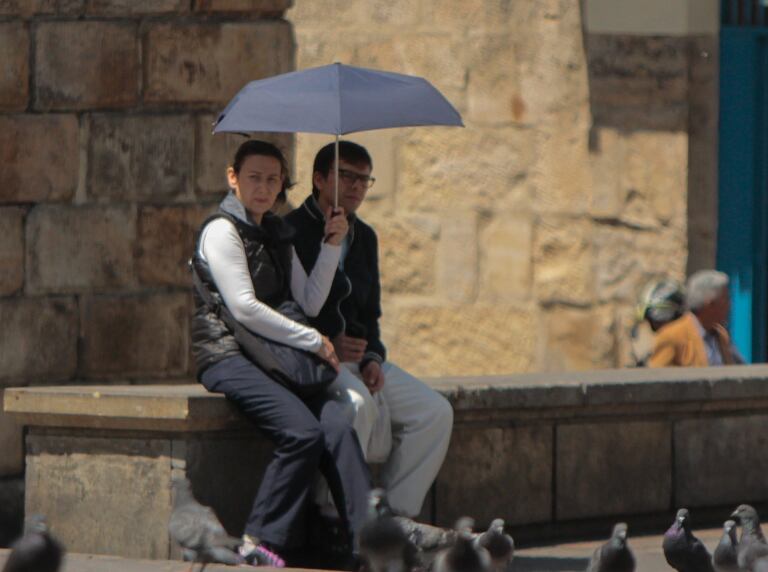 Pareja con sombrilla que se cubre del sol en Bogotá (Colprensa)