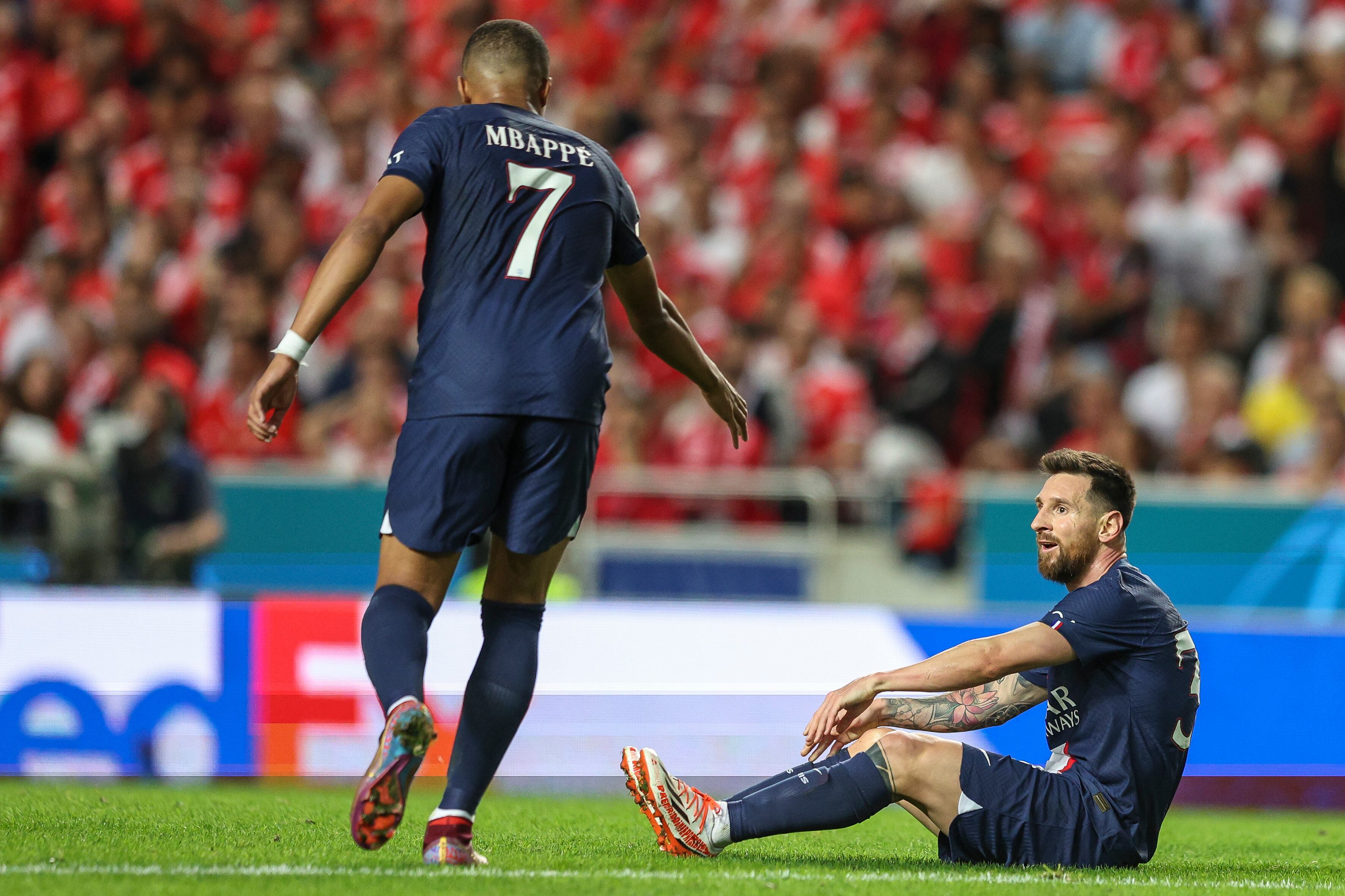 LISBON, PORTUGAL - OCTOBER 05: Kylian Mbappe (L) helps Lionel Messi (R) of Paris Saint-Germain to get up during the UEFA Champions League group H match between SL Benfica and Paris Saint-Germain at Estadio do Sport Lisboa e Benfica on October 5, 2022 in Lisbon, Portugal. (Photo by Carlos Rodrigues/Getty Images)