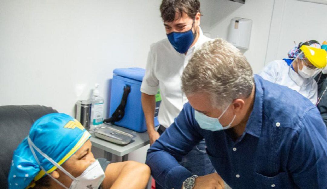 El presidente Iván Duque saluda a Liseidis Pérez, la primera vacunada contra el COVID-19 en Barranquilla. Al fondo el alcalde Jaime Pumarejo.