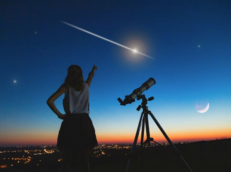 Mujer viendo 'estrella fugaz' desde lo alto de una montaña (Getty Images)