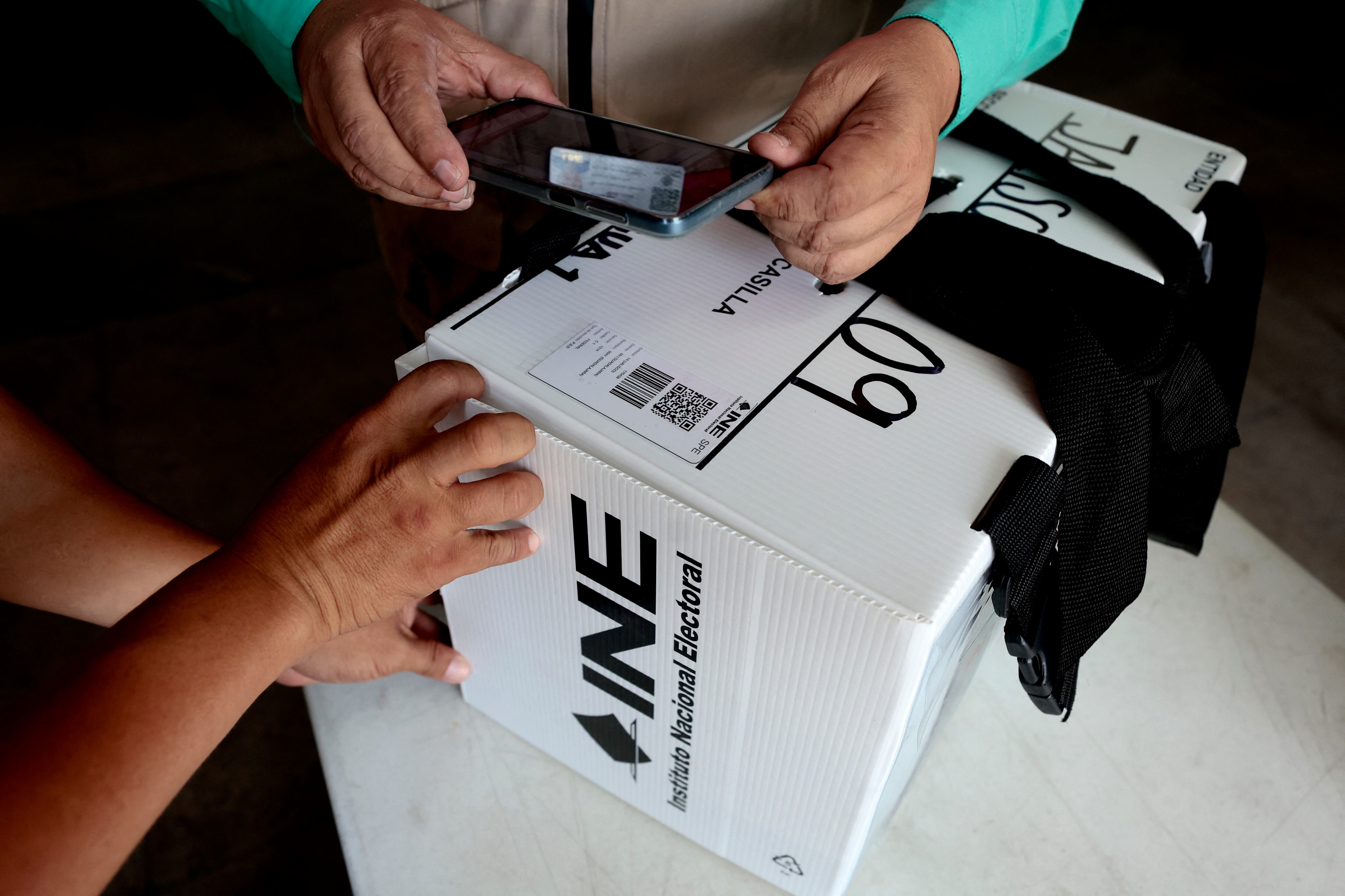 Officials of the National Electoral Institute (INE) register the exit of a package containing electoral material to be used in the upcoming presidential elections in a precinct in Guadalajara, Jalisco state, Mexico, on May 31, 2024. - Millions of Mexicans are expected to vote for their first woman president in a landmark election on June 2, 2024, following a long and sometimes acrimonious race overshadowed by soaring political violence. (Photo by ULISES RUIZ / AFP)