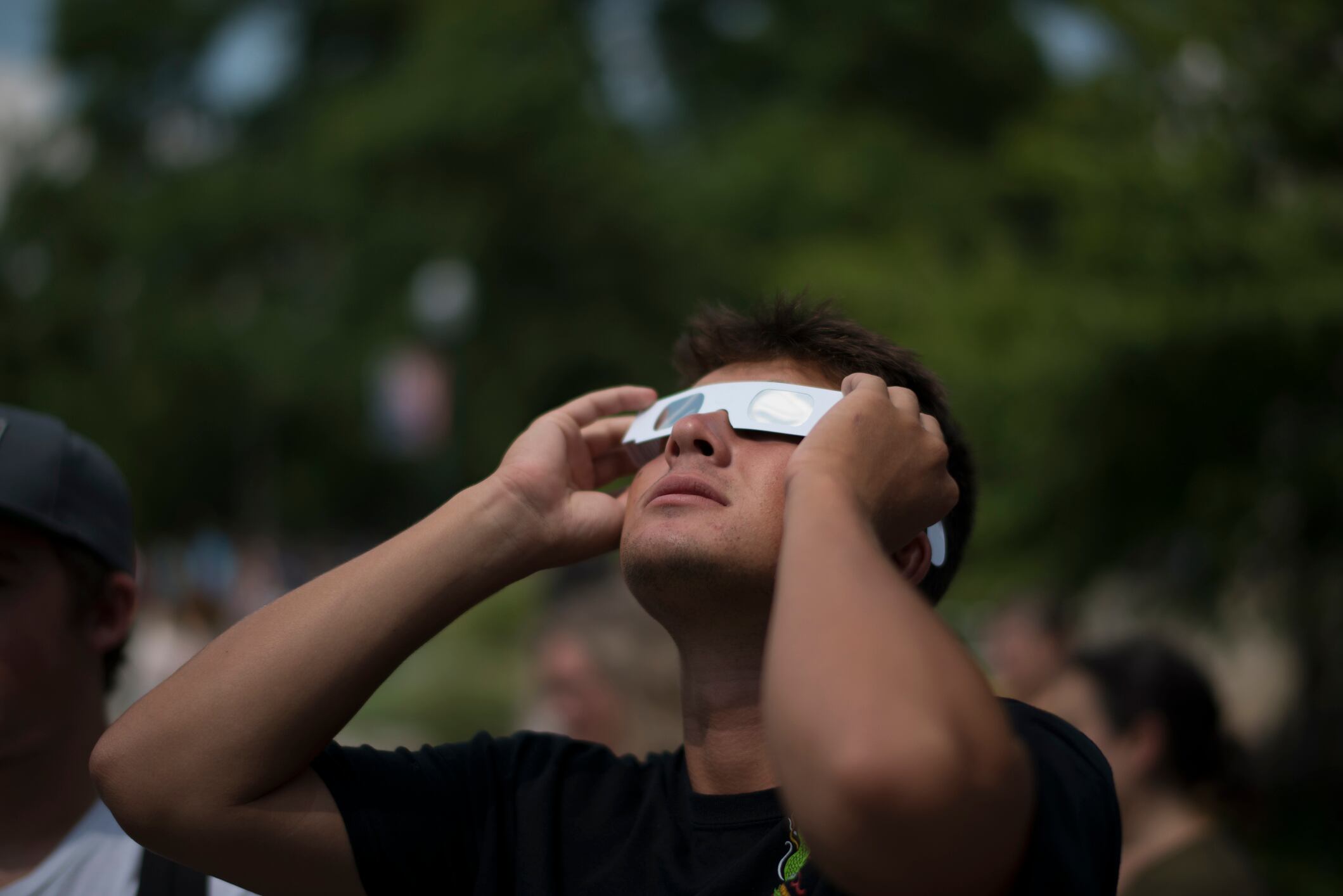 Hombre joven viendo el eclipse solar con gafas de protección (Getty Images)