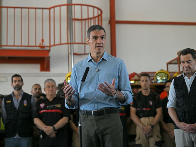 Spain's Prime Minister Pedro Sanchez talks to media next to Andalusian regional president Juan Manuel Moreno (R) after a wildfire that killed at least 13 people, at the command post set in Turre, Almeria Province, on July 13, 2026. The toll from the deadly wildfires in southern Spain rose to 13 on July 12, 2026 after a British woman died of her injuries in hospital, officials in Andalusia region announced. (Photo by JORGE GUERRERO / AFP)